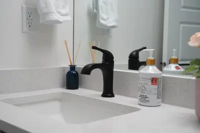 a bathroom counter with a sink and a mirror at The Cozy Nook of Seton in Calgary