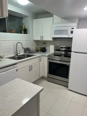 a kitchen with a sink and a stove top oven at Cozy and comfy 1 BEDROOM basement suite at Cougar ridge SW Calgary in Calgary