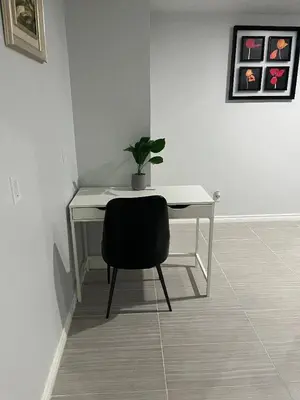 a white desk with a potted plant and a chair at Cozy and comfy 1 BEDROOM basement suite at Cougar ridge SW Calgary in Calgary