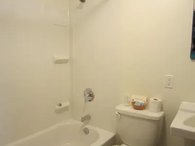a white bathroom with a toilet and a sink at Bulkley Valley Motel in New Hazelton
