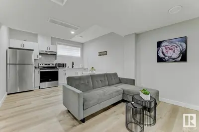 a living room with a couch and a kitchen at Cozy Up in Edmonton