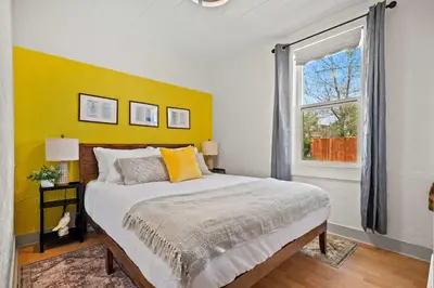 a bedroom with a large bed with a yellow wall at The Canary 2BR Gem in Downtown Drumheller in Drumheller