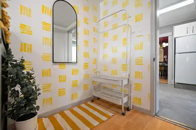 a bathroom with yellow writing on the wall at The Canary 2BR Gem in Downtown Drumheller in Drumheller