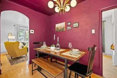 a dining room with a table and a purple wall at The Canary 2BR Gem in Downtown Drumheller in Drumheller