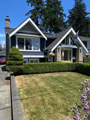 a house with a flag in a yard at Ravens Nest Cozy Lower One Bedroom Suite in Victoria