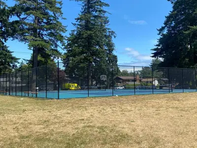 a tennis court in front of a fence at Ravens Nest Cozy Lower One Bedroom Suite in Victoria