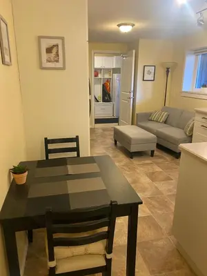 a living room with a table and a couch at Ravens Nest Cozy Lower One Bedroom Suite in Victoria