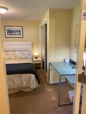 a bedroom with a bed and a blue desk at Ravens Nest Cozy Lower One Bedroom Suite in Victoria