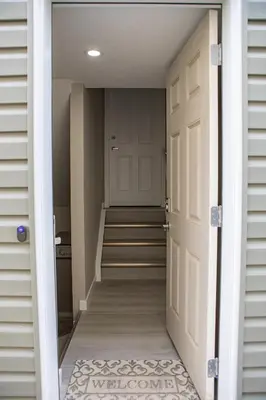 an open door leading to a hallway with stairs at Modern 2-Bedroom Suite with Private Access - 10 minutes from Calgary Airport in Calgary