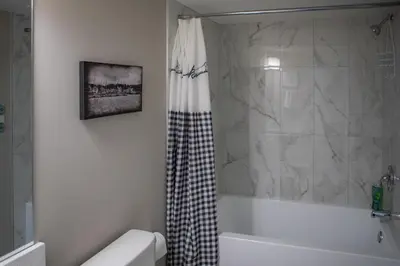 a bathroom with a shower and a tub and a toilet at Modern 2-Bedroom Suite with Private Access - 10 minutes from Calgary Airport in Calgary