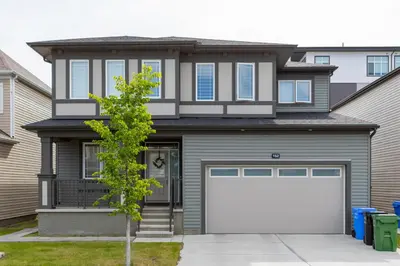 a house with a white garage door at Modern 2-Bedroom Suite with Private Access - 10 minutes from Calgary Airport in Calgary