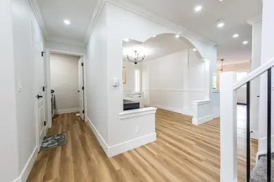an open hallway with white walls and wood floors at Valley Villa Spacious 5BD Getaway! Sleep 12, 1hr to Banff, 40 Mins Canmore, 5 mins to WinSport & Olympic park in Calgary