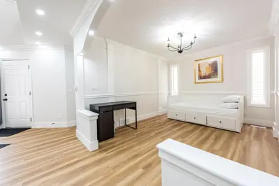 a white room with a bed and a desk at Valley Villa Spacious 5BD Getaway! Sleep 12, 1hr to Banff, 40 Mins Canmore, 5 mins to WinSport & Olympic park in Calgary