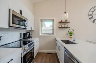 a white kitchen with a sink and a microwave at Mountain View Hideaway - BBQ, Beach Access in Invermere