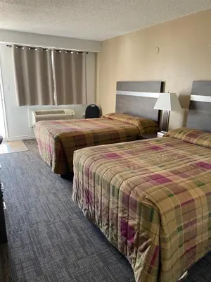 a hotel room with two beds and a window at Hilltop Motor Inn in Elk Point