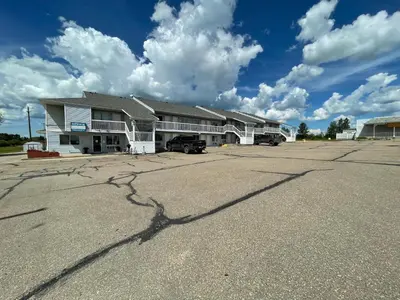 a building with a parking lot in front of it at Hilltop Motor Inn in Elk Point