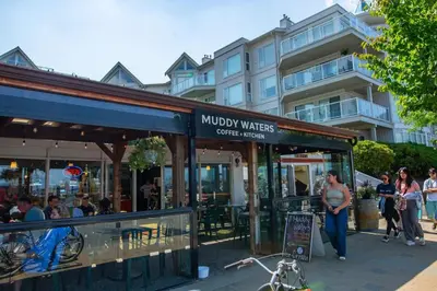 a coffee shop with people standing outside of it at The Riverbend Modern Studio at Harrison Lake in Harrison Hot Springs