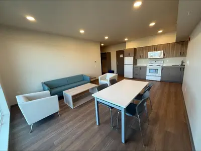 a living room with a couch and a table and chairs at Residence & Conference Centre - Kelowna in Kelowna