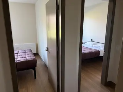 a room with a bedroom with a bed and a doorway at Residence & Conference Centre - Kelowna in Kelowna
