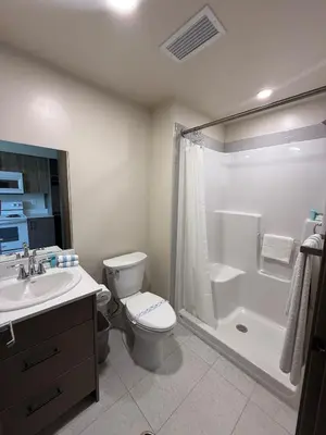 a bathroom with a toilet and a shower and a sink at Residence & Conference Centre - Kelowna in Kelowna