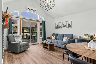 a living room with a couch and a table at Mountain Views Balcony and Free Parking in Canmore