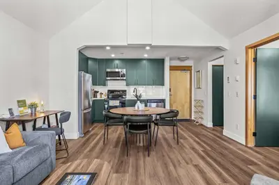 a living room with a table and chairs and a kitchen at Mountain Views Balcony and Free Parking in Canmore