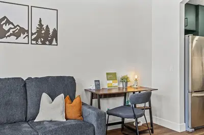 a living room with a couch and a table at Mountain Views Balcony and Free Parking in Canmore