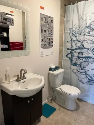 a bathroom with a sink and a toilet and a shower curtain at The Flight Line in Calgary