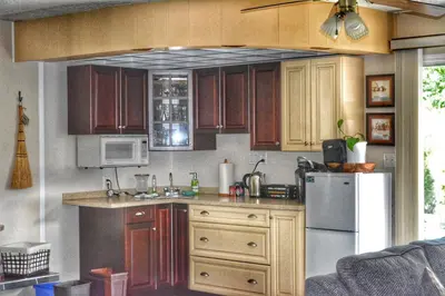 a kitchen with wooden cabinets and a refrigerator at Sunny Shuswap B&B in Chase