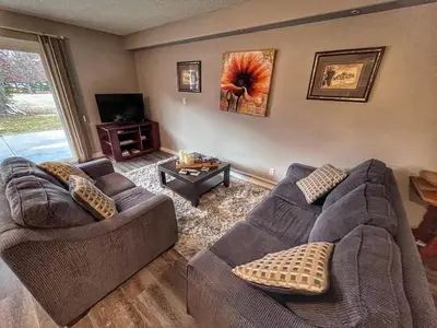 a living room with two couches and a tv at Sunny Shuswap B&B in Chase