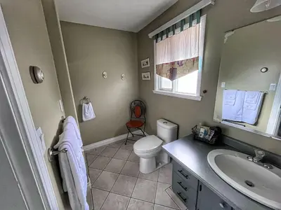 a bathroom with a sink and a toilet and a mirror at Sunny Shuswap B&B in Chase