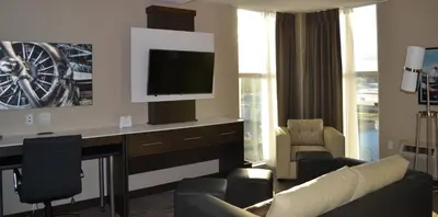 a living room with a couch and a desk with a tv at Holiday Inn Express & Suites Cold Lake by IHG in Cold Lake