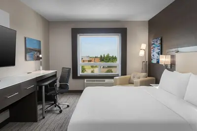 a hotel room with a bed and a desk and a window at Holiday Inn Express & Suites Cold Lake by IHG in Cold Lake