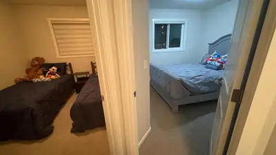 a bedroom with two beds and a teddy bear sitting on a bed at Calgary Airport Getaway Spacious 3BR Full Home in Calgary