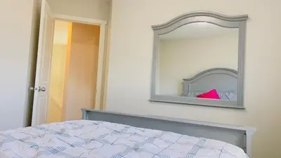 a bedroom with a bed and a mirror on the wall at Calgary Airport Getaway Spacious 3BR Full Home in Calgary