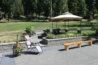 a bench and a chair and an umbrella in a park at Remo Ridge Bed N Breakfast in Terrace