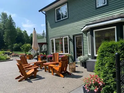 a group of wooden chairs and an umbrella in front of a building at Remo Ridge Bed N Breakfast in Terrace