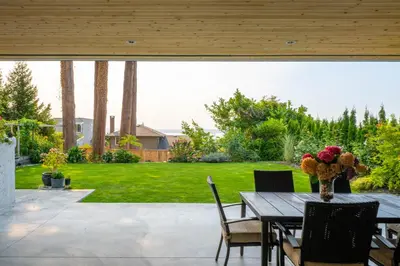 a table with a vase of flowers on a patio at New 2BR Suite With Great Ocean View in West Vancouver in West Vancouver