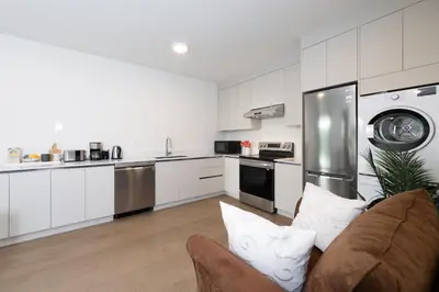 a living room with a couch and a kitchen at New 2BR Suite With Great Ocean View in West Vancouver in West Vancouver