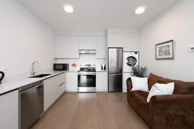 a kitchen and living room with a couch and appliances at New 2BR Suite With Great Ocean View in West Vancouver in West Vancouver