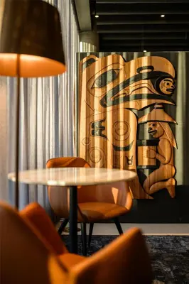 a table with chairs and a lamp in a room at Hyatt Place Whitehorse in Whitehorse