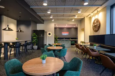 a restaurant with tables and chairs and a bar at Hyatt Place Whitehorse in Whitehorse