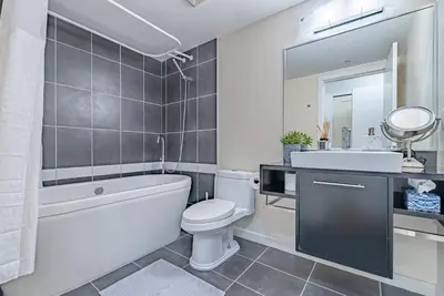 a bathroom with a tub and a toilet and a sink at Downtown Condo with Great City Views in Vancouver