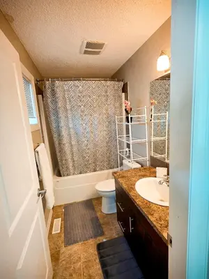 a bathroom with a sink and a toilet and a shower at Stonecroft House in Calgary
