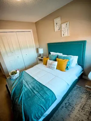 a large bed with a blue headboard in a bedroom at Stonecroft House in Calgary