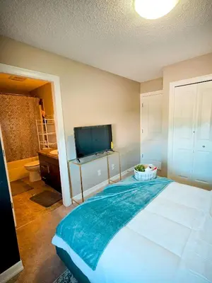 a bedroom with a large bed and a flat screen tv at Stonecroft House in Calgary