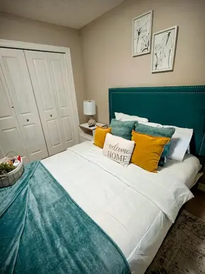a bedroom with a large bed with yellow and blue pillows at Stonecroft House in Calgary