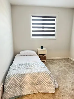 a bedroom with a large bed and a window at Home in west Edmonton in Edmonton