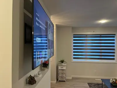 a living room with a large flat screen tv on the wall at Home in west Edmonton in Edmonton