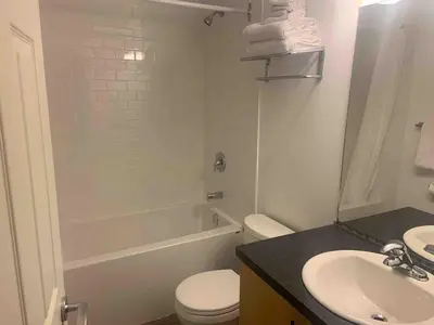 a bathroom with a white toilet and a sink at Rocky Mountain Gem - One Level 750 sq ft - Hot Tub - Quiet Condo - Self Check-In - Free Parking - BBQ Fire Pit Area in Canmore